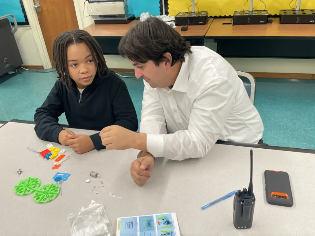 Instructor mentoring a student during a robotics activity